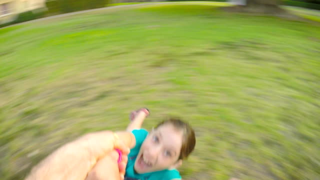 POV-footage-of-father-swinging-his-daughter-outdoors