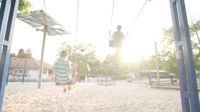 Children-swinging-together-at-a-public-playground