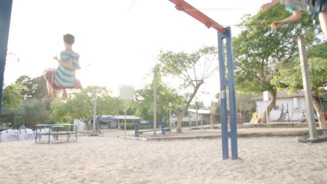 Kinder-schwingen-zusammen-auf-einem-öffentlichen-Spielplatz