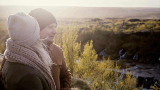 Hermosa-joven-pareja-permanente-en-Valle-soleado-y-hablando,-disfrutando-de-la-hermosa-vista-en-Islandia