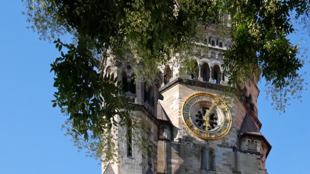 Clock-of-Kaiser-Wilhelm-Memorial-Church-Behind-A-Tree-In-Berlin,-Germany