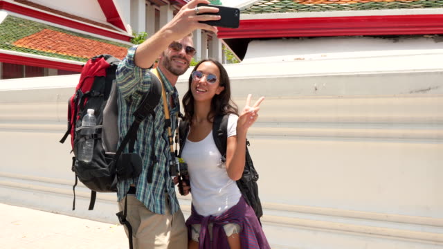 Touristischen-paar-nehmen-Selfie-mit-Smartphone-in-Thai-Tempel-in-Bangkok,-Thailand