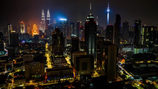 lapso-de-tiempo-k-4-con-paisaje-de-tráfico-de-la-ciudad-de-Kuala-Lumpur-con-dos-torres-sobre-un-fondo.-Vista-aérea.