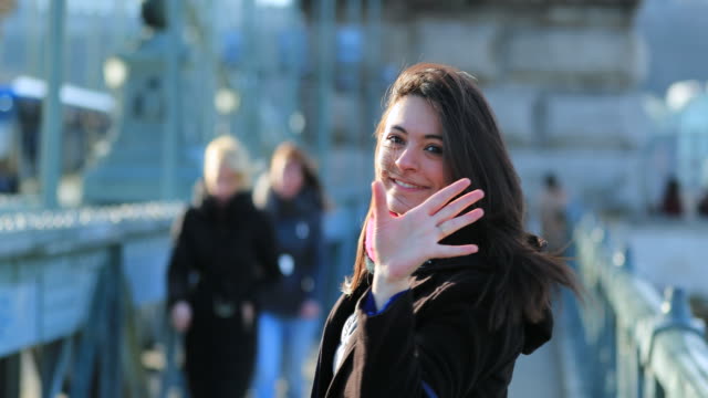 Woman-waving-hello-to-camera-in-4K-welcoming-viewer