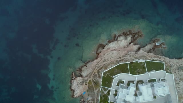 Luftaufnahme-des-großen-weißen-Villen-mit-Garten-vorne-am-Meer-in-Griechenland.