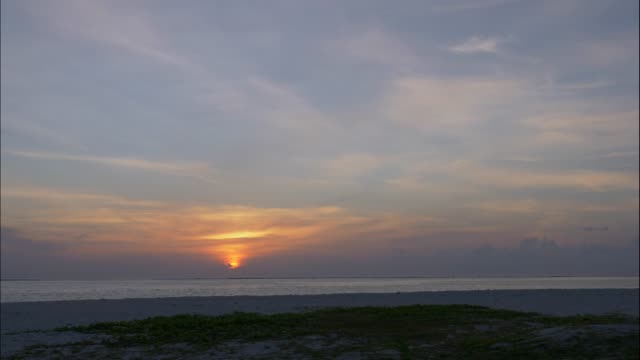 Zeitraffer-auf-den-Sonnenuntergang-vom-Strand-entfernt