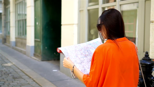 Young-woman-with-a-city-map-in-city.-Travel-tourist-girl-with-map-in-Vienna-outdoors-during-holidays-in-Europe.