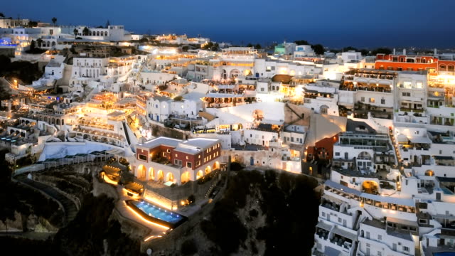 Lapso-Hyper-sobrevuelo-de-la-ciudad-de-Fira-(Thira)-en-puesta-del-sol,-isla-de-Santorini,-Grecia