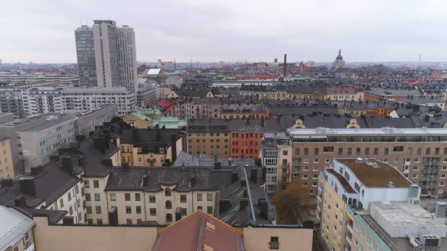 Vista-aérea-de-edificios-de-la-ciudad-de-Stockholm-en-barrio-de-Södermalm.-Tiro-de-Drone-volando-sobre-los-tejados,-rascacielos-en-el-fondo.-Horizonte-de-paisaje-urbano,-Capital-de-Suecia