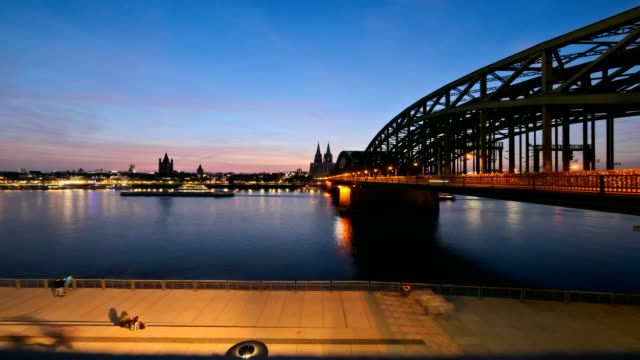 Cologne-cathedral-and-Hohenzollern-bridge-lighting-up-at-dusk