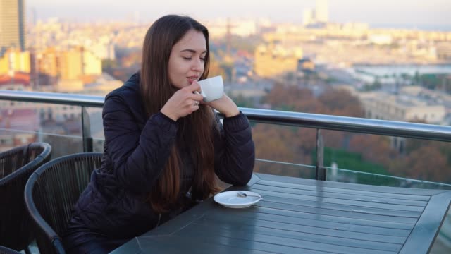 lady-drinking-coffee-at-outdoor-cafe-with-amazing-view-in-barcelona