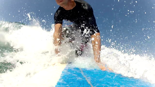 CLOSE-UP:-Young-surfer-paddling-and-surfing