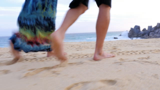 Close-up-of-the-feet-of-an-older-couple-walking-down-the-beach