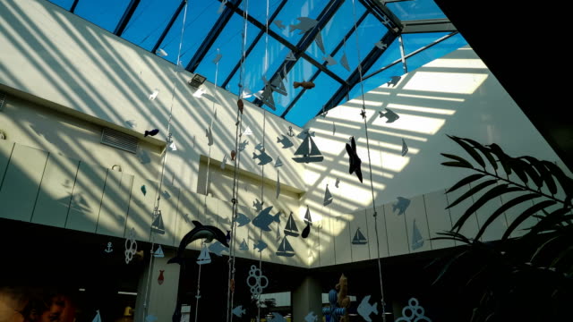 Gläserne-Decke-des-Shopping-Centers-mit-Papier-Girlanden-auf-einem-Hintergrund-von-Time-Lapse-Licht-der-Sonnenstrahlen-auf-einen-blauen-Himmel