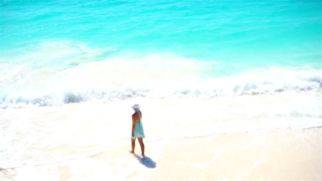 Happy-girl-at-beach-walking-in-shallow-water.-Top-view-on-a-woman-on-the-white-beach