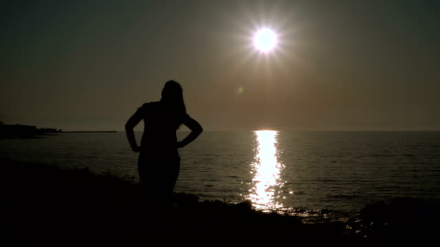 Das-Mädchen-entwickelt-Haare-am-Strand-bei-Sonnenuntergang.