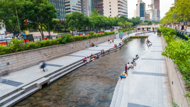 Parque-de-arroyo-de-Cheonggyecheon-con-multitud-de-personas-relajación-en-Seúl,-Corea-del-sur.-Lapso-de-tiempo-de-4K