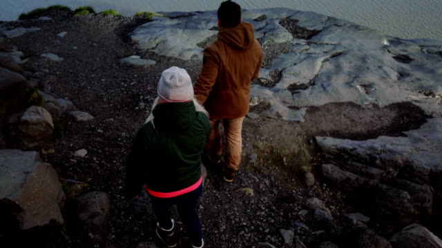 Joven-pareja-viaja-caminando-por-las-montañas,-ir-a-ver-los-glaciares-en-la-laguna-de-hielo-Vatnajokull-juntos