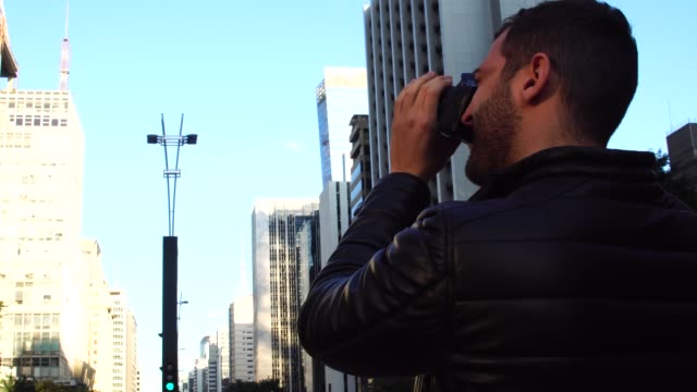Man-photographing-the-Avenida-Paulista,-Sao-Paulo,-Brazil