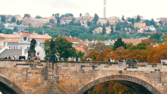 Puente-de-Carlos-de-Praga-sobre-el-río-Vltava,-en-el-cual-las-muchedumbres-de-turistas-pasear