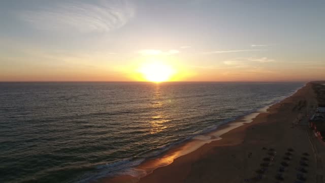Fliegen-über-dem-Faro-Strand-(Praia-de-Faro)-bei-Sonnenuntergang,-Algarve,-Portugal
