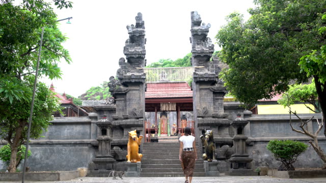 Una-mujer-en-una-falda-larga-asciende-los-pasos-a-un-templo-budista