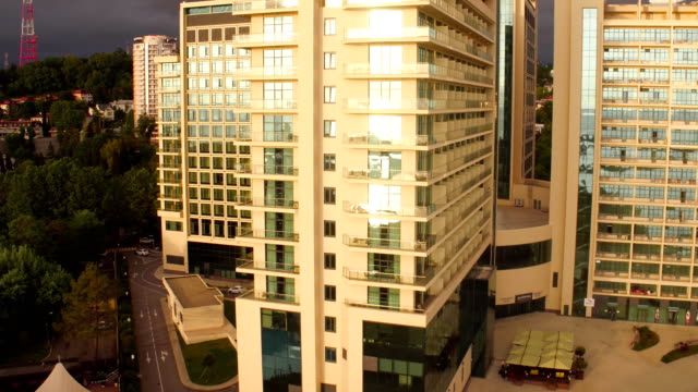 Modern-multi-storey-buildings-with-mirror-Windows-at-sunset,-aerial-shot