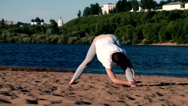 Frau,-dehnen,-Yoga-am-Strand-am-Fluss-in-der-Stadt.-Schöne-Aussicht.