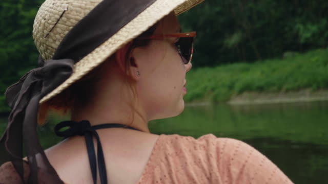 Chica-joven-canoa-en-un-lago-y-mirando-el-paisaje-en-agua-soleada