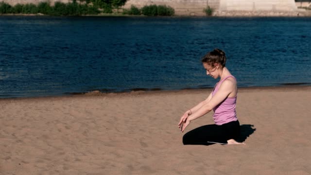 Frau,-dehnen,-Yoga-am-Strand-am-Fluss-in-der-Stadt.-Blick-auf-die-schöne-Stadt.-Atemübung.