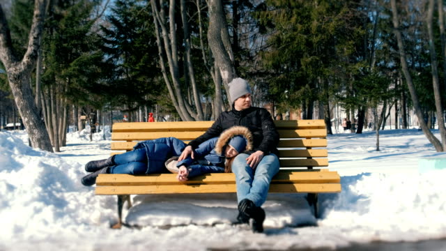 Hombre-y-una-mujer-estar-juntos-en-un-banco-en-la-ciudad-de-winter-Park.-Día-soleado-de-invierno.