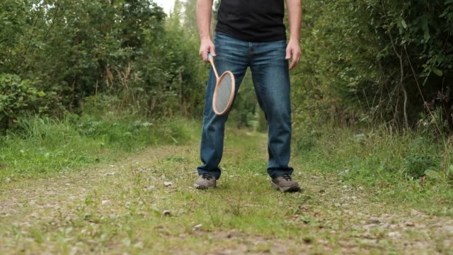 Reifer-kaukasischen-Mann-Badminton-im-Freien-spielen.
