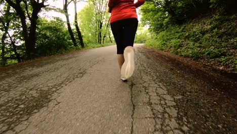 Running-girl.-Blonde-girl-doing-outdoor-sports-in-the-summer-forest.-Rear-view-slow-motion-wide-angle.-Close-up-of-a-girl's-legs