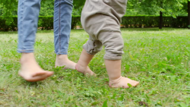 Madre-y-bebé-caminar-descalzo-sobre-la-hierba
