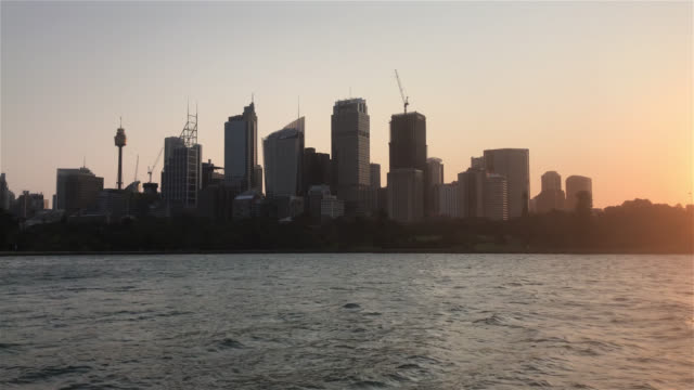Establishing-shot-of-Sydney-city-skyline-at-harbour-during-sunset.