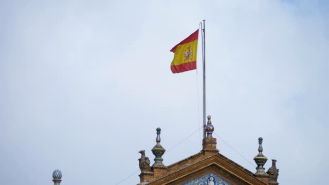 Spanish-national-flag-waving-in-Plaza-de-Espana---Sevilla,-Spain
