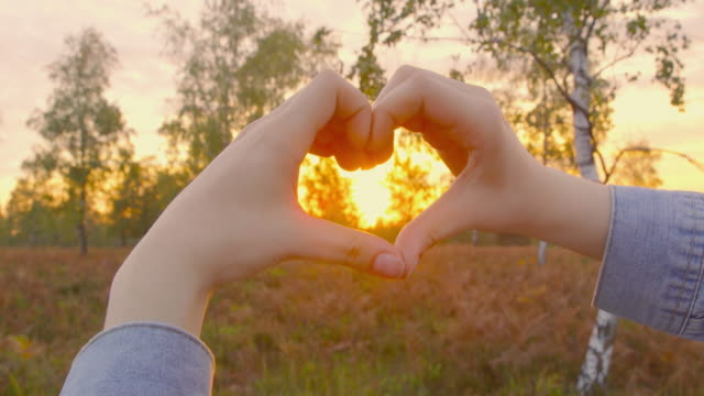 Nature-loving---Beautiful-young-woman-forming-a-heart-shape-with-her-hands