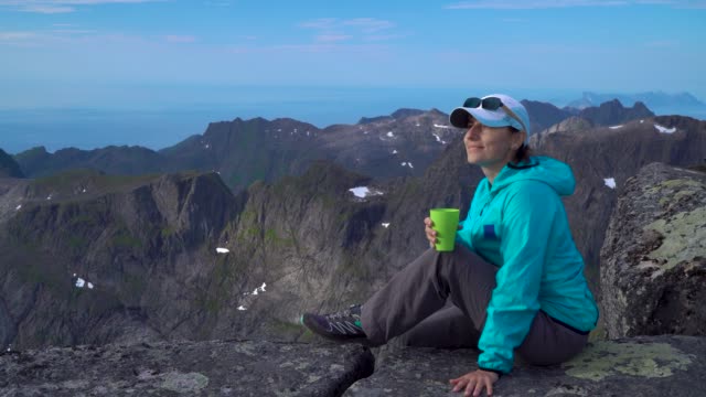 Una-niña-está-bebiendo-té-en-las-montañas