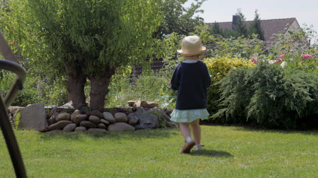 Kind-Bewässerung-Baum-im-Hinterhof