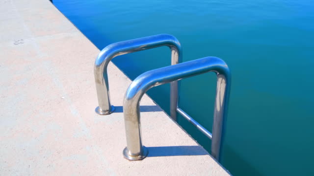Shiny-chrome-metal-stair-on-the-pier-down-to-the-water