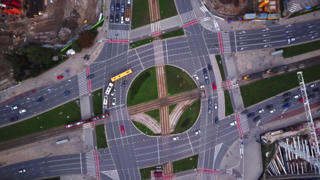 Luftaufnahme-der-Stadt,-das-über-eine-Stadt-fliegt,-ein-suggestives-senkrecht-Luftvideo-über-einem-Kreisverkehr-mit-viel-Verkehr