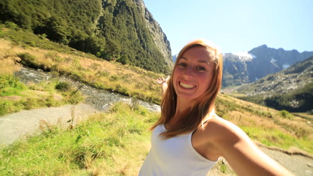 Young-woman-takes-selfie-portrait-in-beautiful-New-Zealand's-landscape