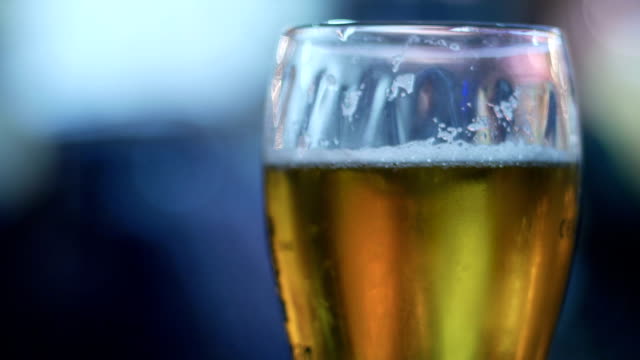 Beer-Glass-in-a-Pub.-Close-up-of-beer-glass-with-blur-background-stock-footage