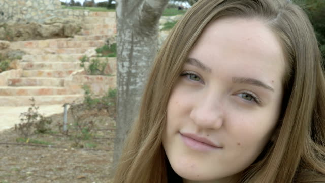 Teenager-Mädchen-lächelnd-und-Blick-auf-die-Kamera-hautnah-Porträt.