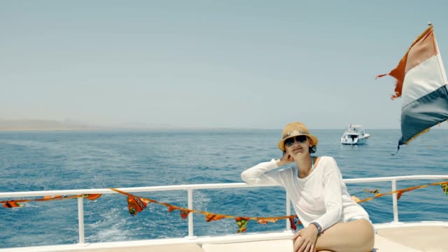 Woman-enjoying-a-trip-on-yacht-sitting-on-deck,-Egypt