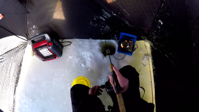 Mann,-Eisfischen-in-schneereichen-Region-vorbereiten