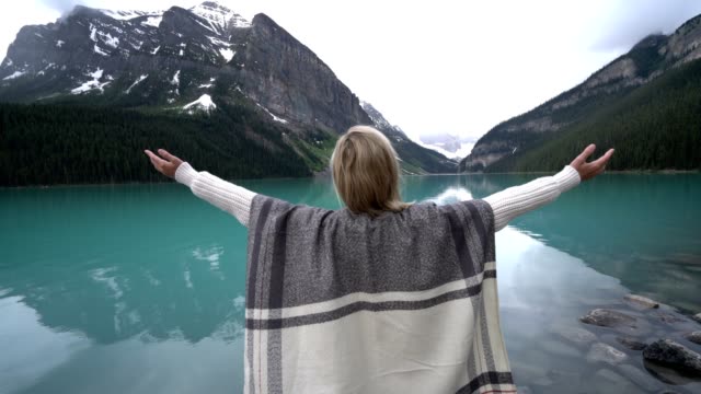 Young-woman-arms-outstretched-at-Lake-Louise