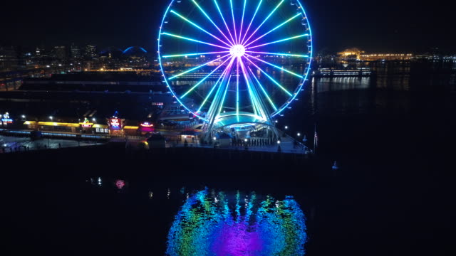Seattle-Waterfront-Aerial-with-Ferry-Boat-Passing-Pier-at-Night