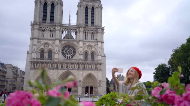 Joven-tomando-selfie-en-París-en-Notre-dame-de-la-ciudad-mediante-teléfono-móvil