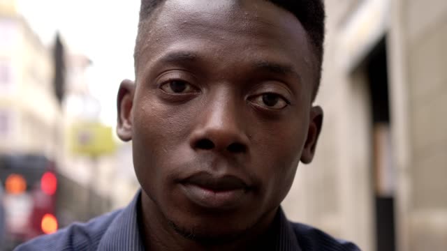 Nachdenklichen-jungen-afrikanischen-Mann-starrte-auf-Kamera-outdoor
